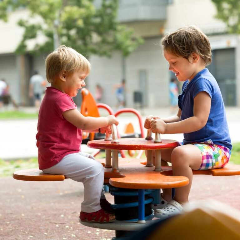 Excited children having fun at playground in sunny day