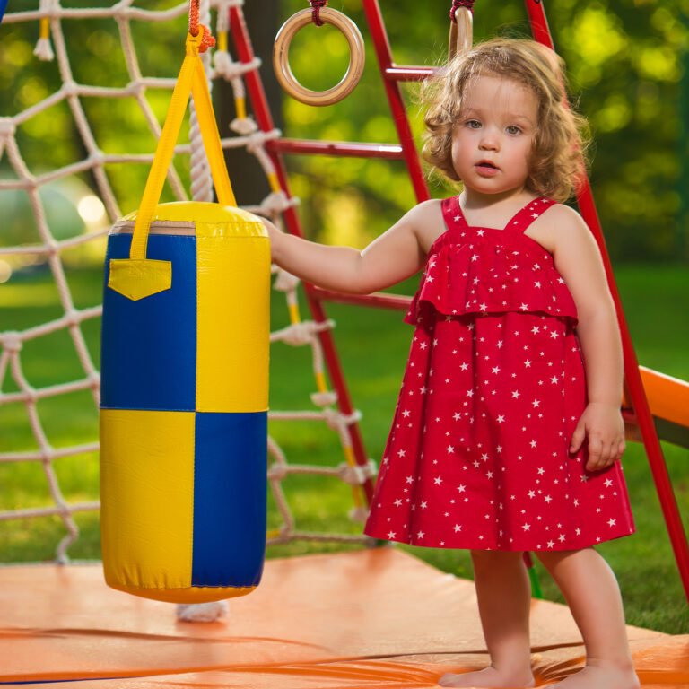 The little baby girl playing at outdoor playground against green grass